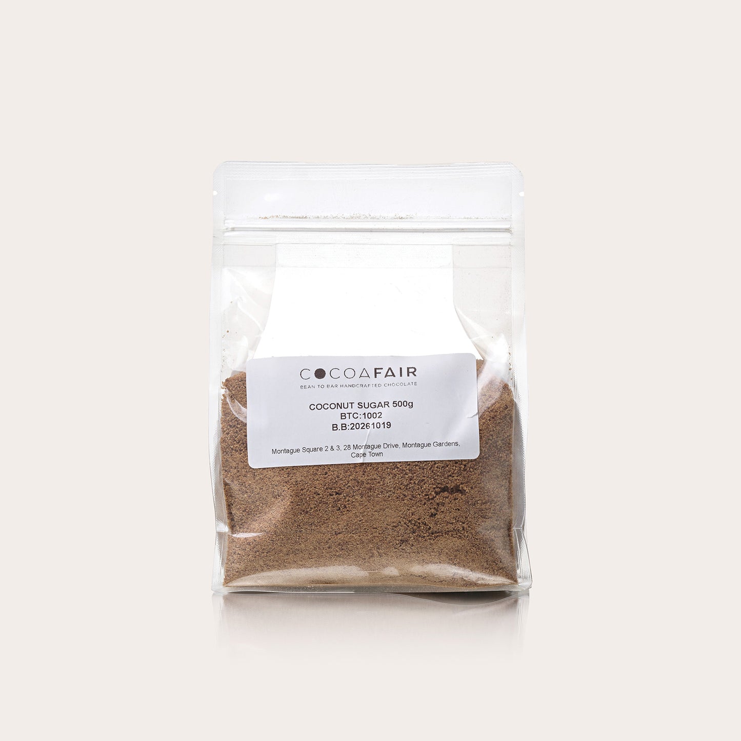 Clear 500g plastic packaging with coconut sugar against a white background, front of packaging